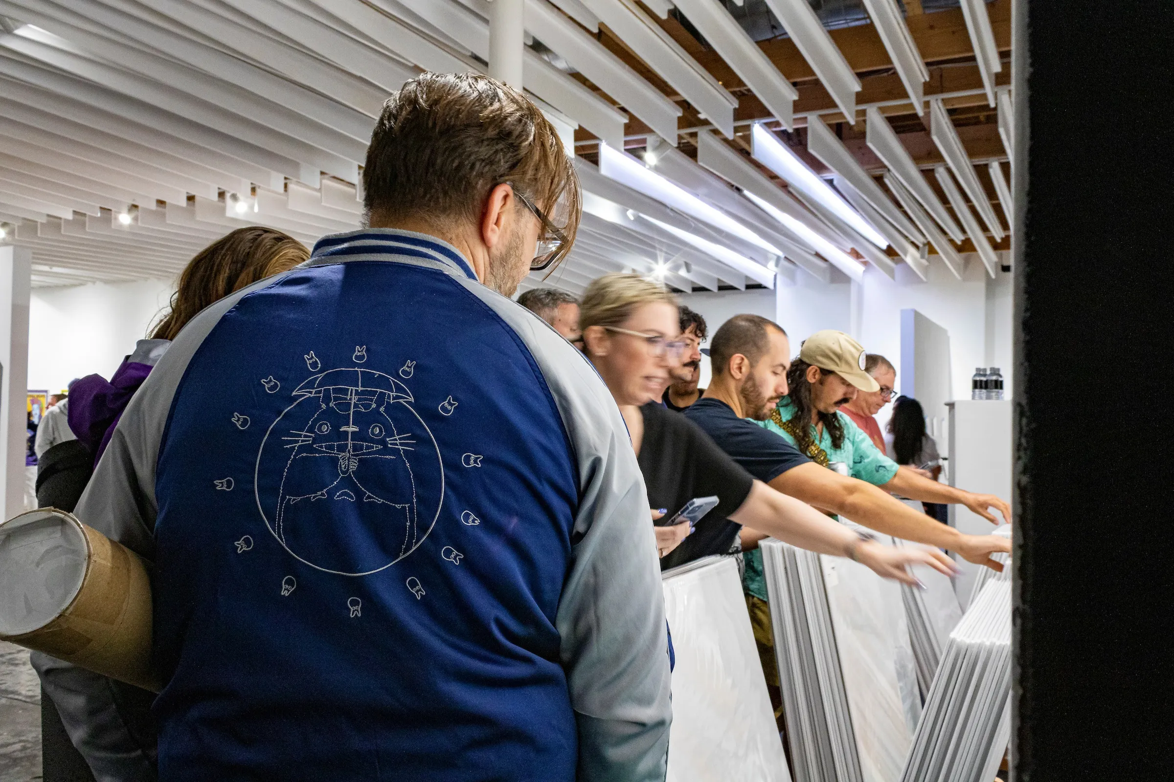 Photograph of a crowd admiring Chuck Sperry's artwork.