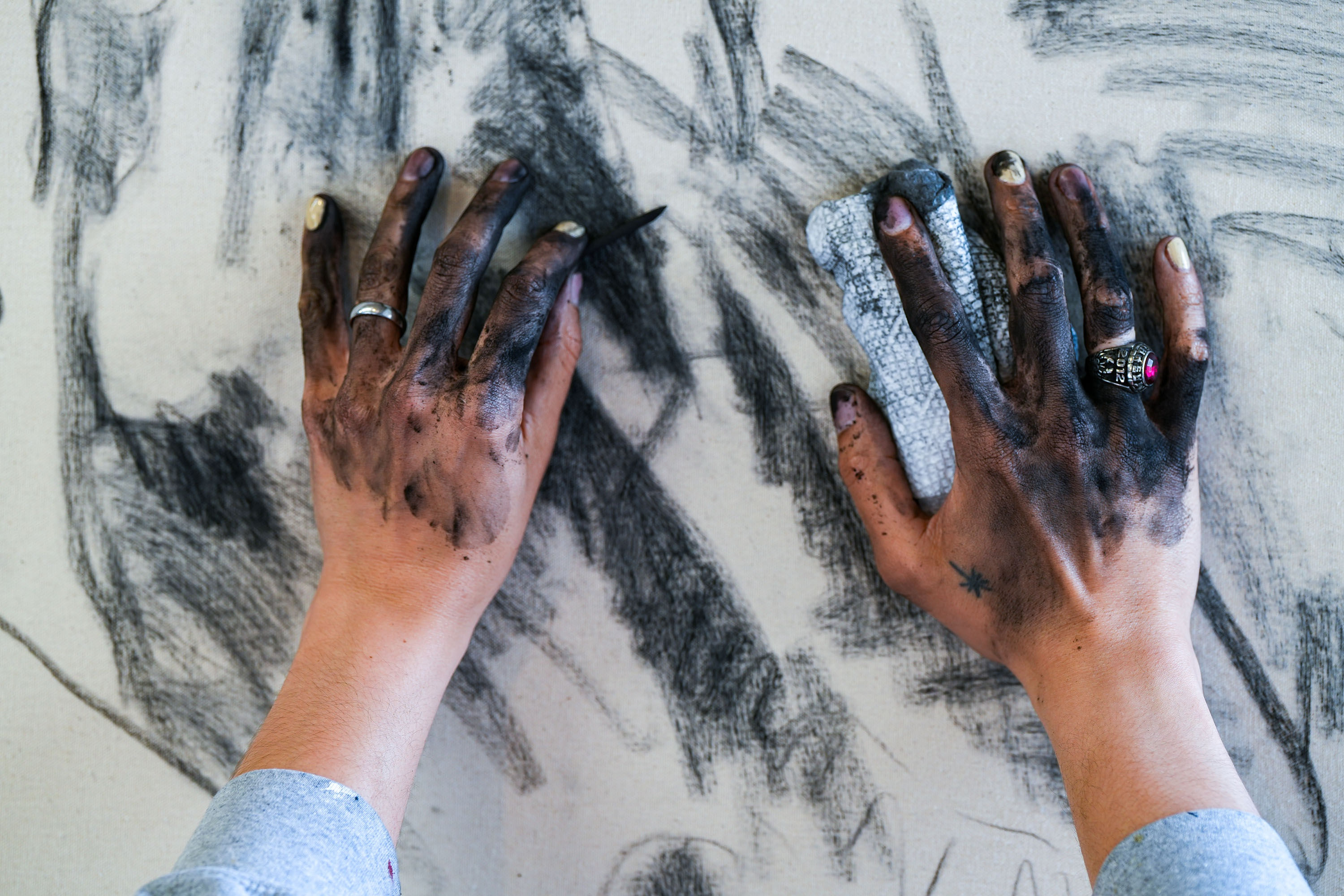 photo of the artist creating charcoal drawings in his studio