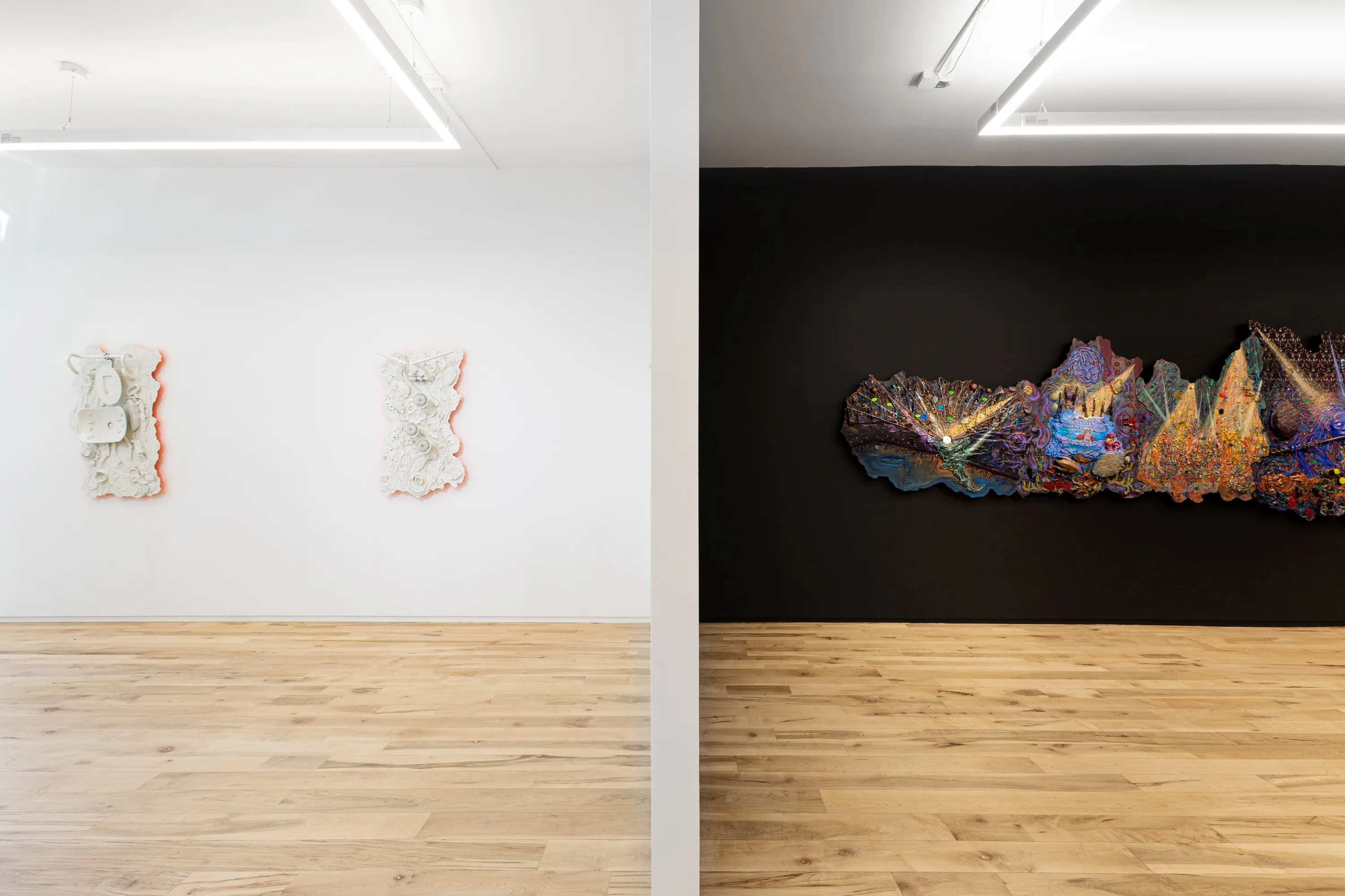 A room split with a black wall on the right and a white wall on the left 