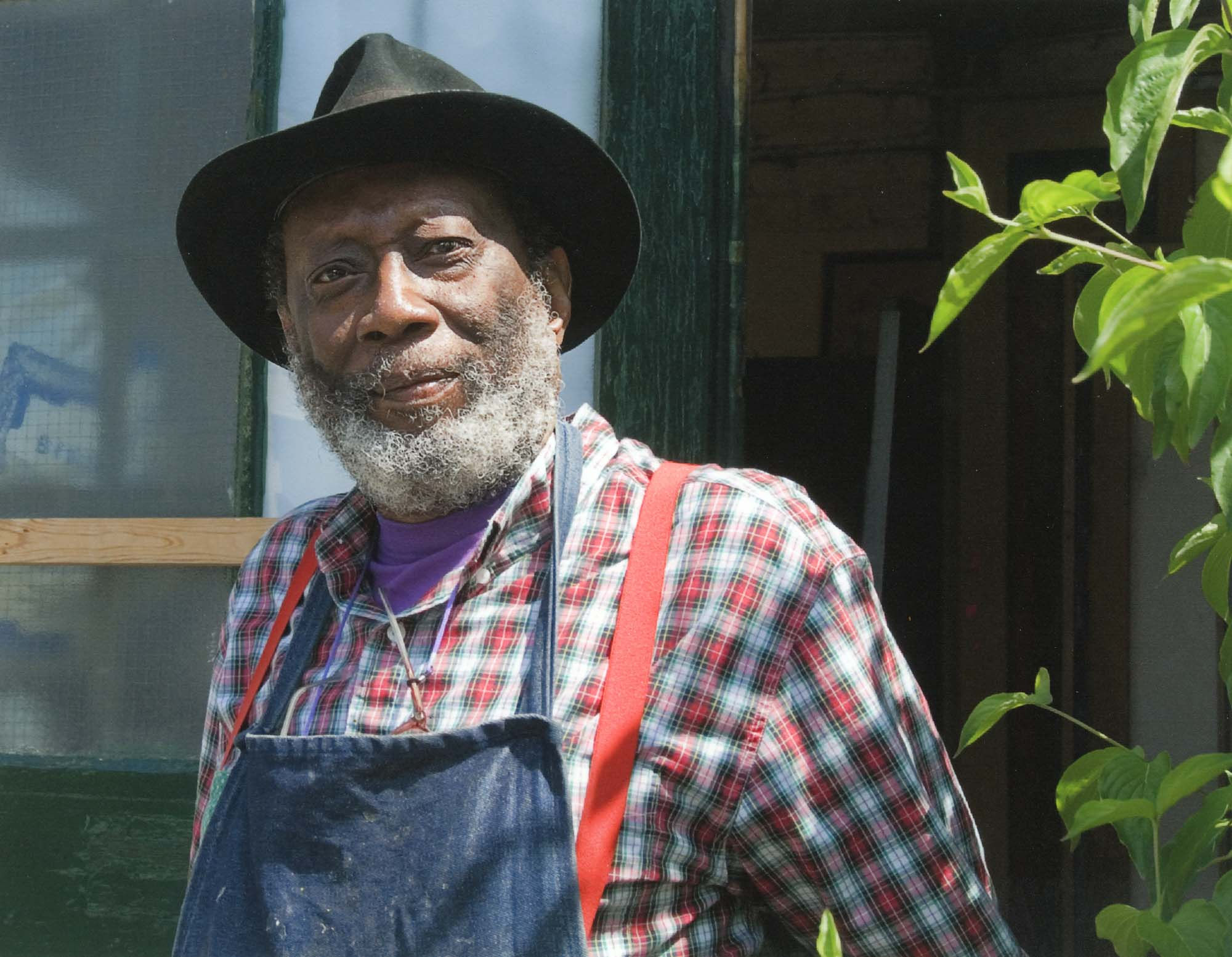Photograph of Frank Bowling standing in front of his London studio in Peacock Yard, taken by Dennis Toff in 2007. &copy; Estate of the late Dennis Toff FPRS. Courtesy Frank Bowling Archive