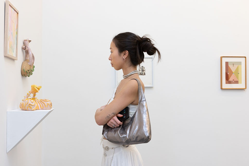 person looking at art at the amuse-bouche opening reception