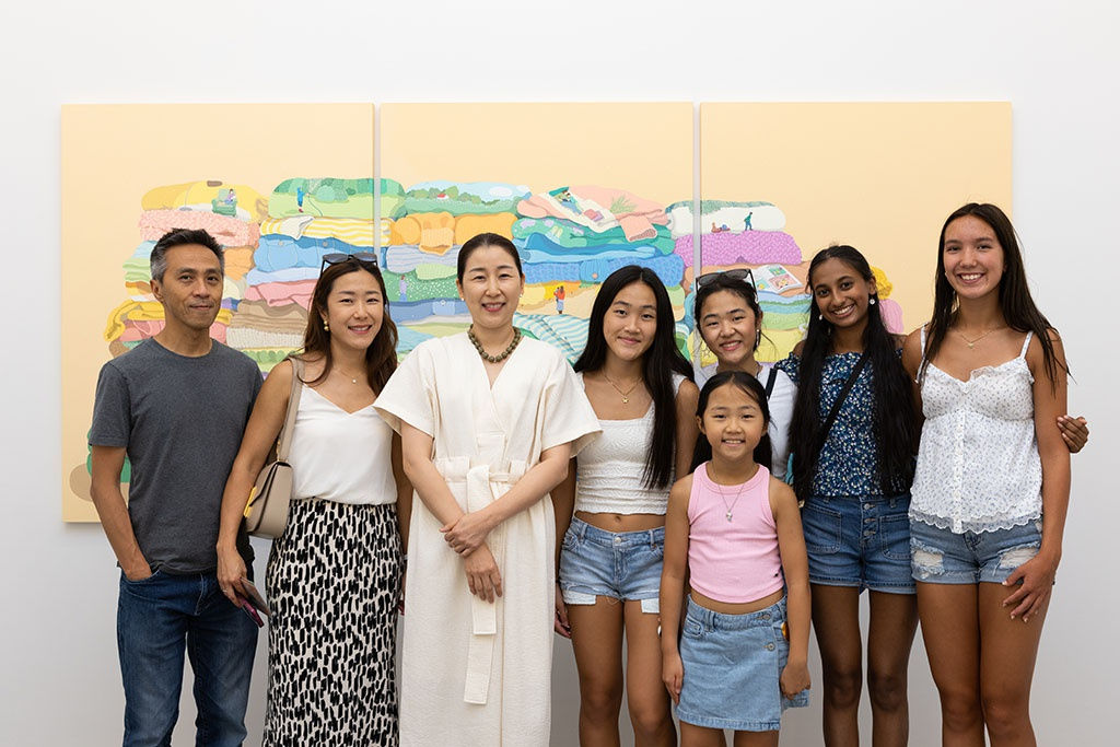 Danym kwon with friends and family standing in front of her large paintings