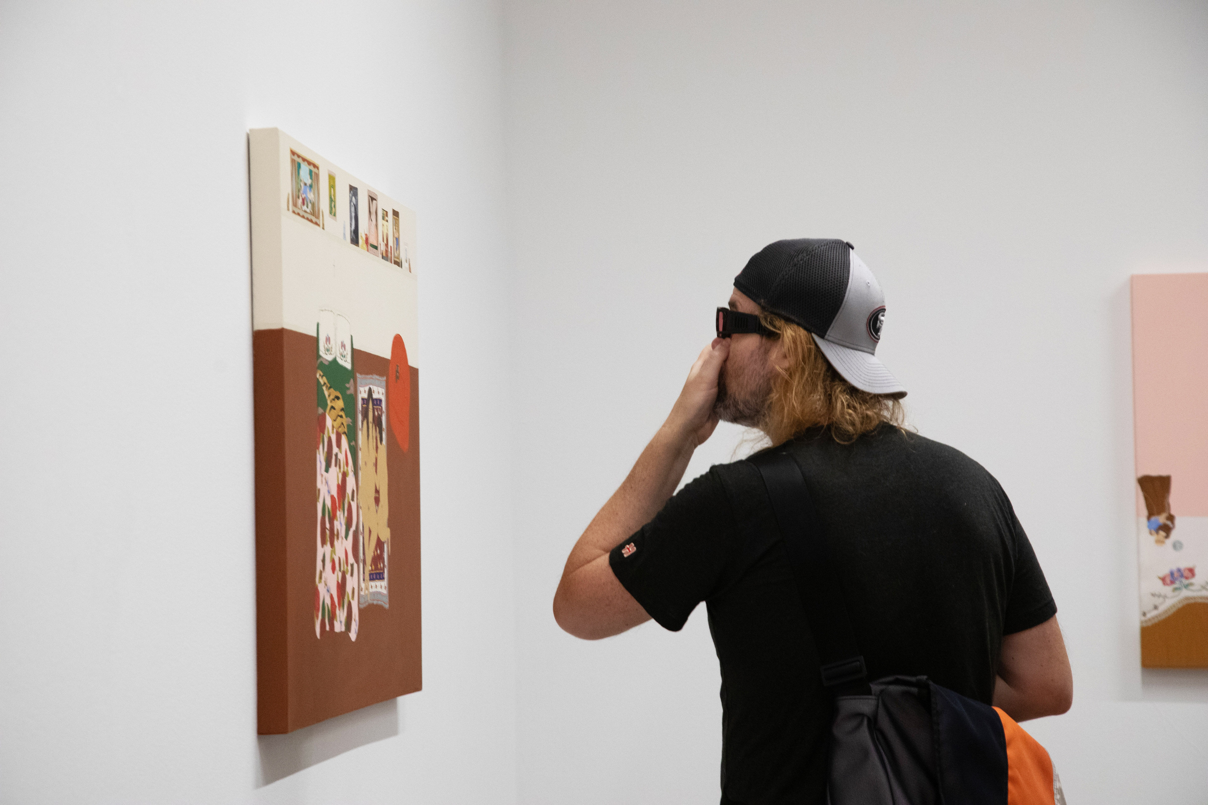 A visitor admires one of Gina M. Contreras's paintings at the opening of the exhibition.