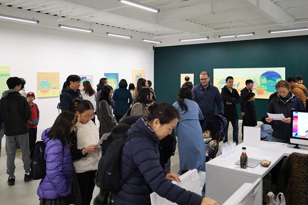 A huge group of people hangout in the gallery space where Danym Kwon's solo exhibition