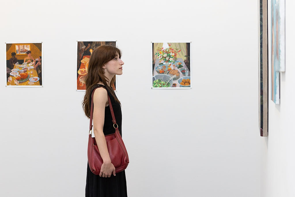 A person standing in front of work at the opening of Left Unsaid