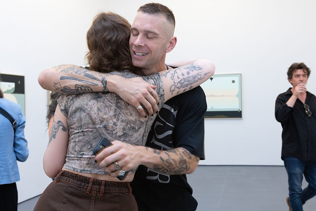 three people talking in a gallery