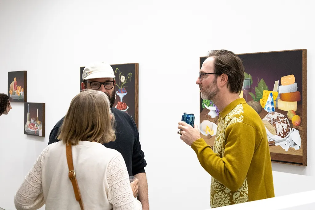 Artist Casey Gray talks to friends at the opening