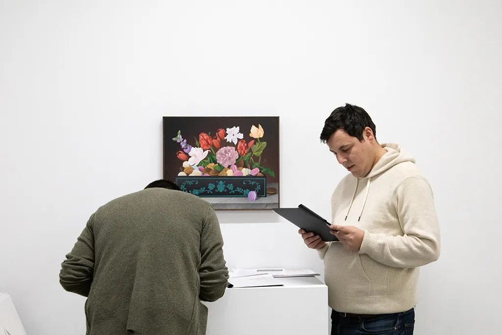 People read the press releases at an art gallery opening reception. 