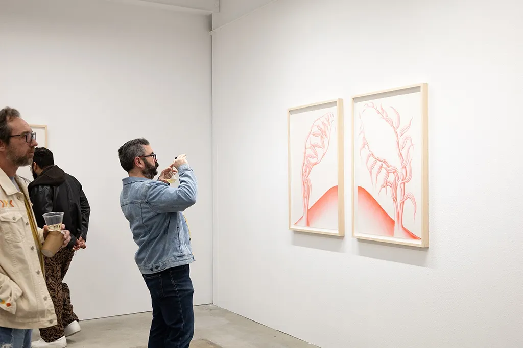 People take pictures of Devra Fox's work at the opening of her solo exhibition. 