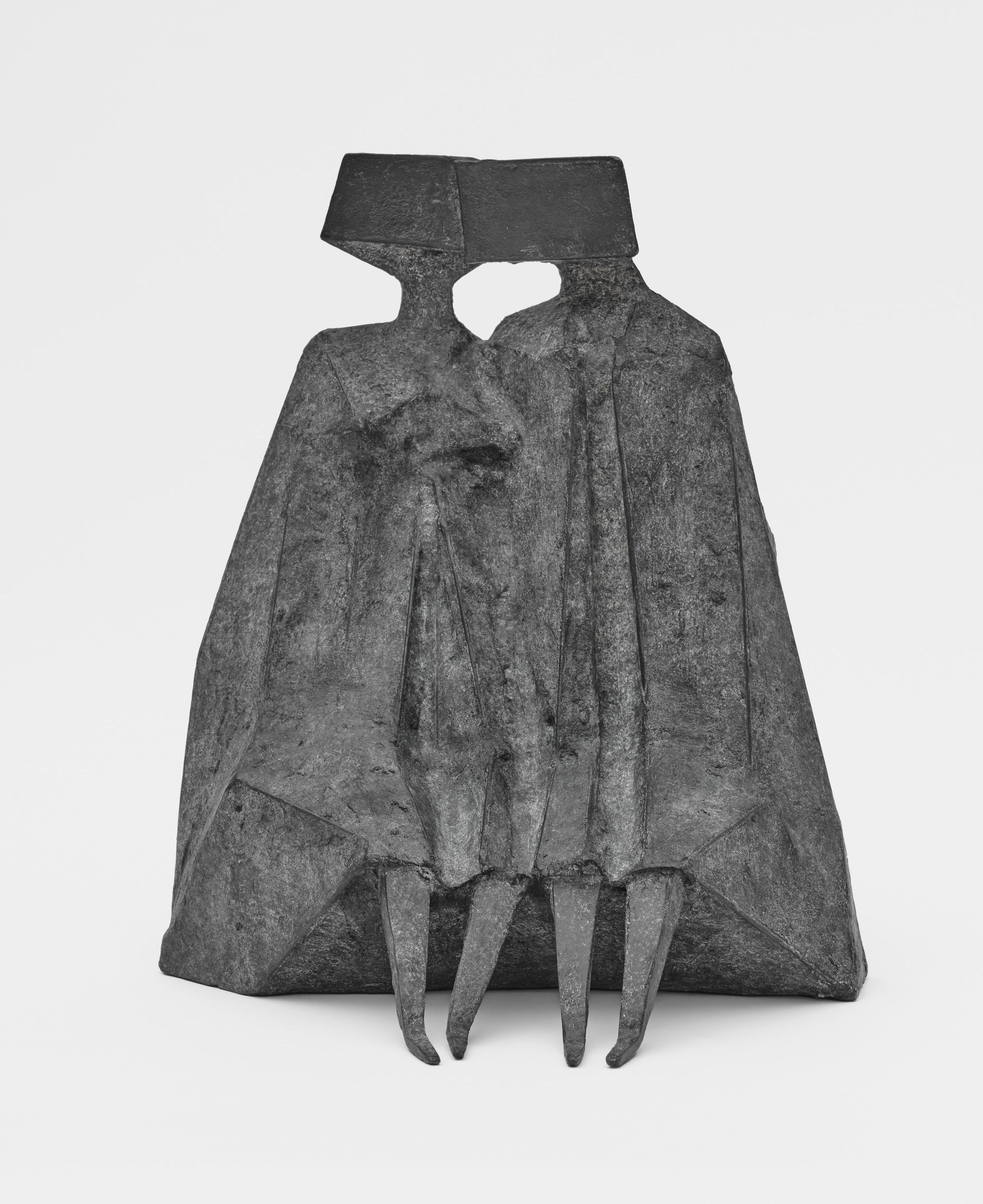 Lynn Chadwick’s “Sitting Couple” (1979), a bronze sculpture of two stylised, block-headed figures seated closely together, their bodies merging into a single angular form with sharp, claw-like extensions at the base.