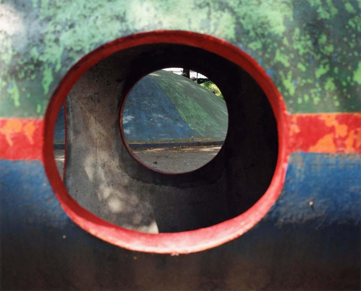 Abstract color photo showing a view through a colorful piece of playground equipment.