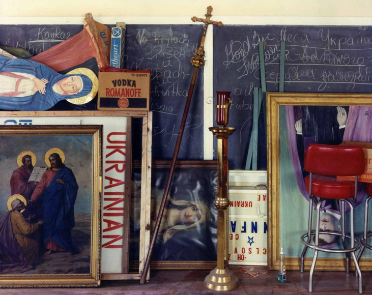 Color photo of a storage space in a church, showing a jumble of religious paraphernalia.