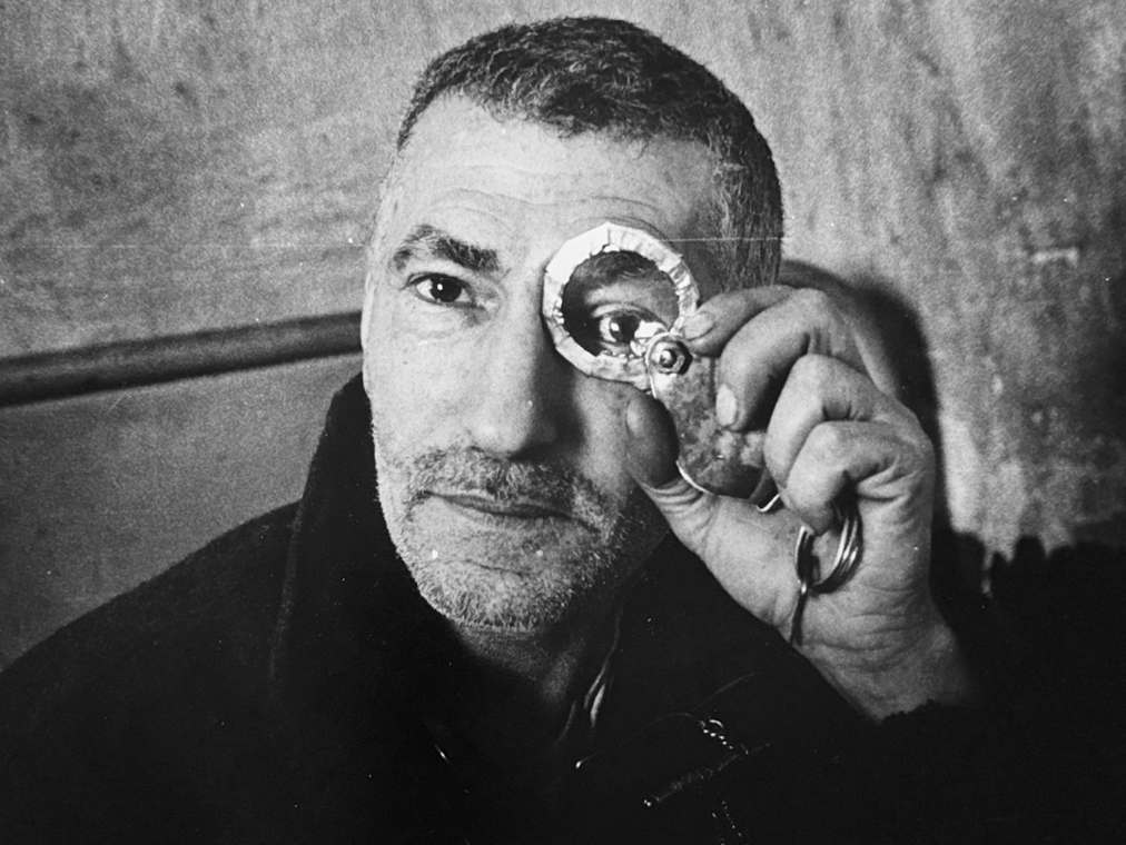 A man looks through a silver ring keychain in this black and white photo courtesy of Rolf Art.