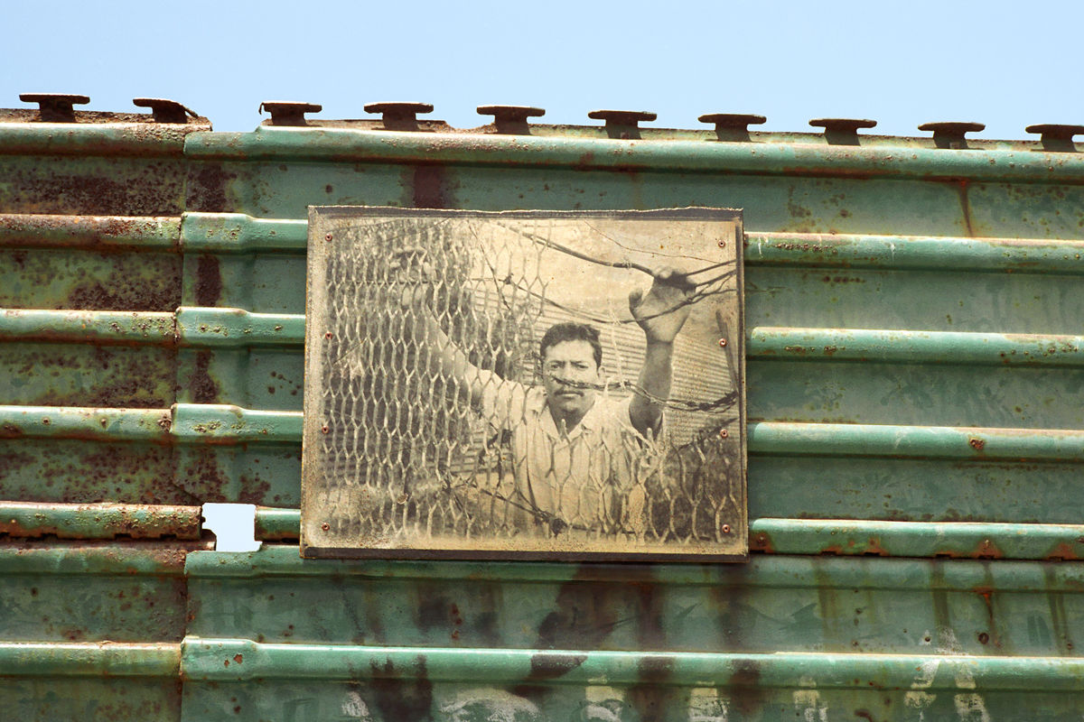 Portrait of migrant printed on steel mounted to U.S.-Mexico border wall