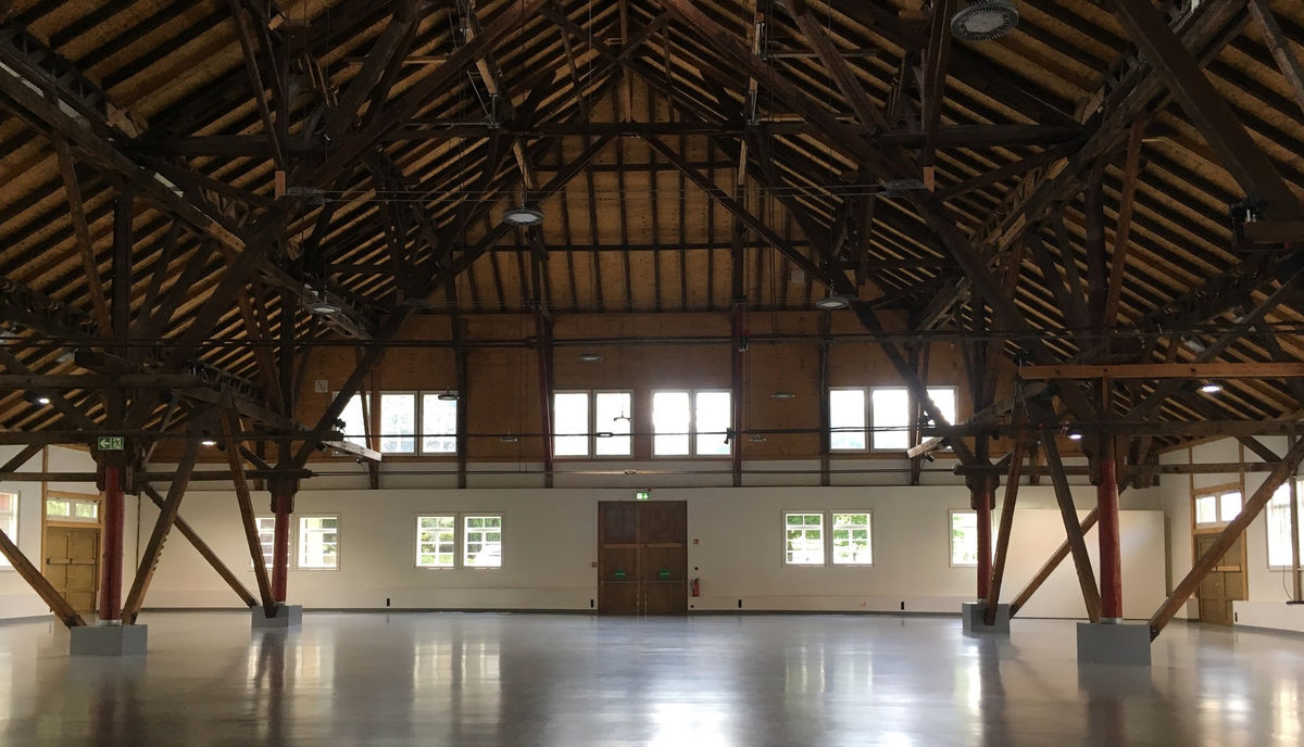 A large warehouse space is filled with wooden scaffolding. 