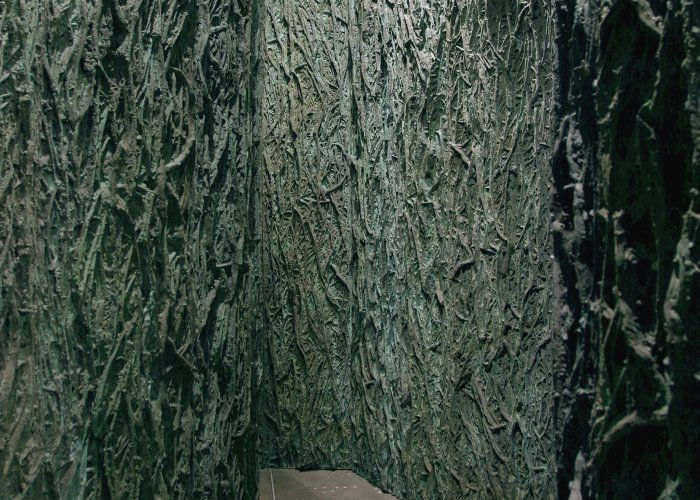 Installation image of tall green panels with a bark-like texture. 