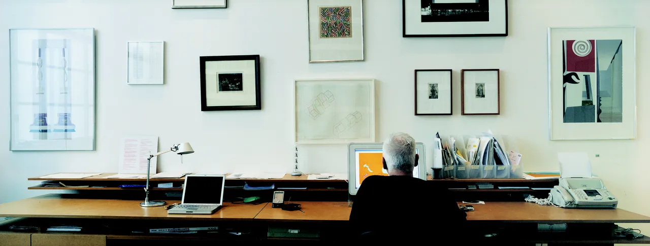 Studio photo of Michael Craig-Martin with his collection of original prints.