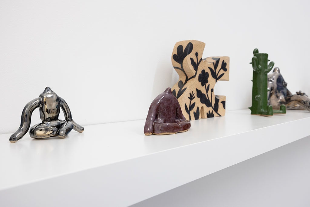 white shelf with assorted ceramic figures by Jocelyn Tsaih