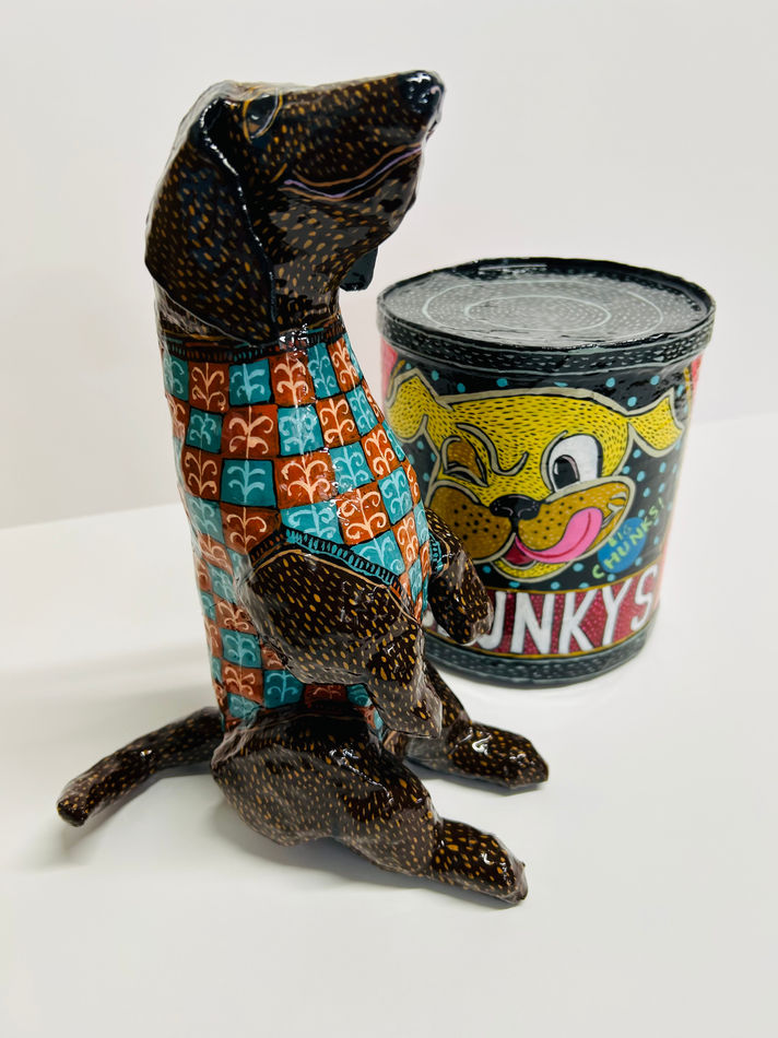 Mark Gagnon - sculptures of a black dog standing on its hind legs and a can with image of a dog head and the text 
