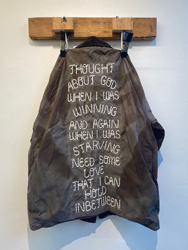 Henry Harper embroidered jacket hanging on wooden wall hook