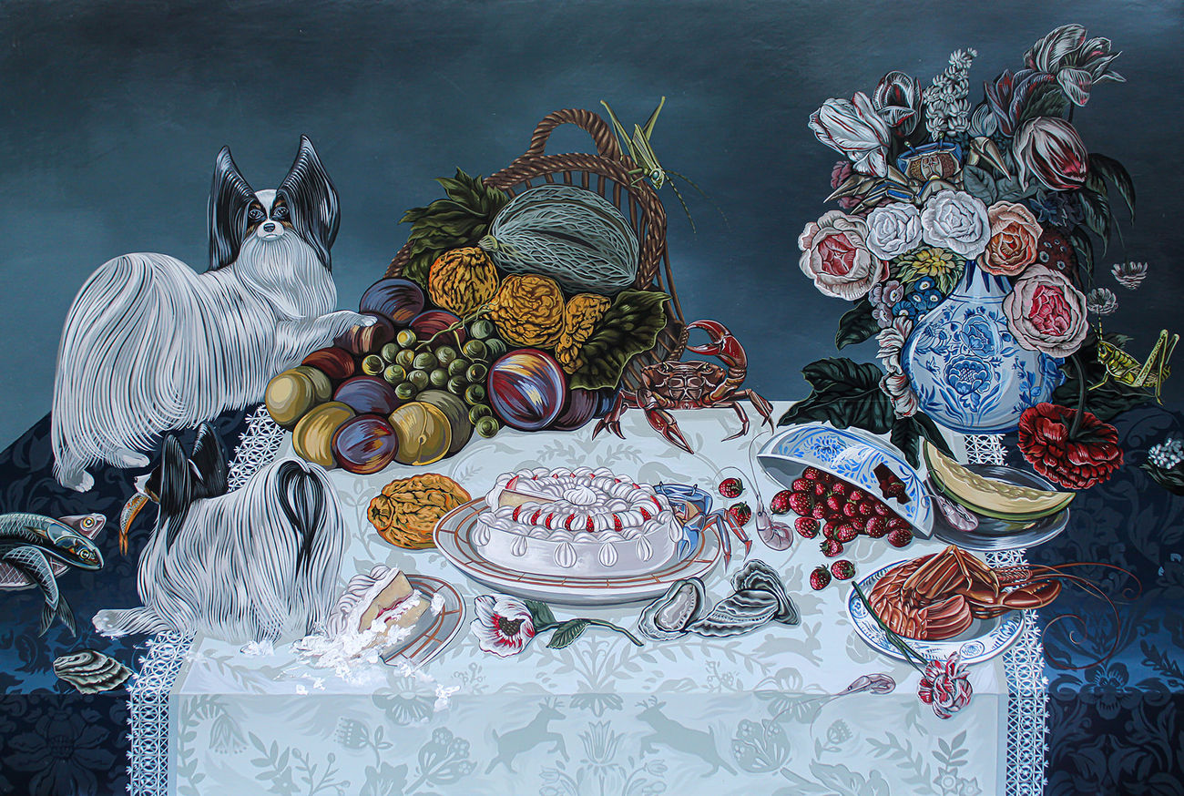 Tablescape painting of two black and white dogs on a table full of decadent food, including a basket of fruit with a grasshopper on it, a giant bouquet of flowers, a bowls of strawberries that has been know knocked over, a plate of giant shrimp, a bowl of whole fish and a white frosted cake that one of the dogs has walked into and gotten frosting all over the table.