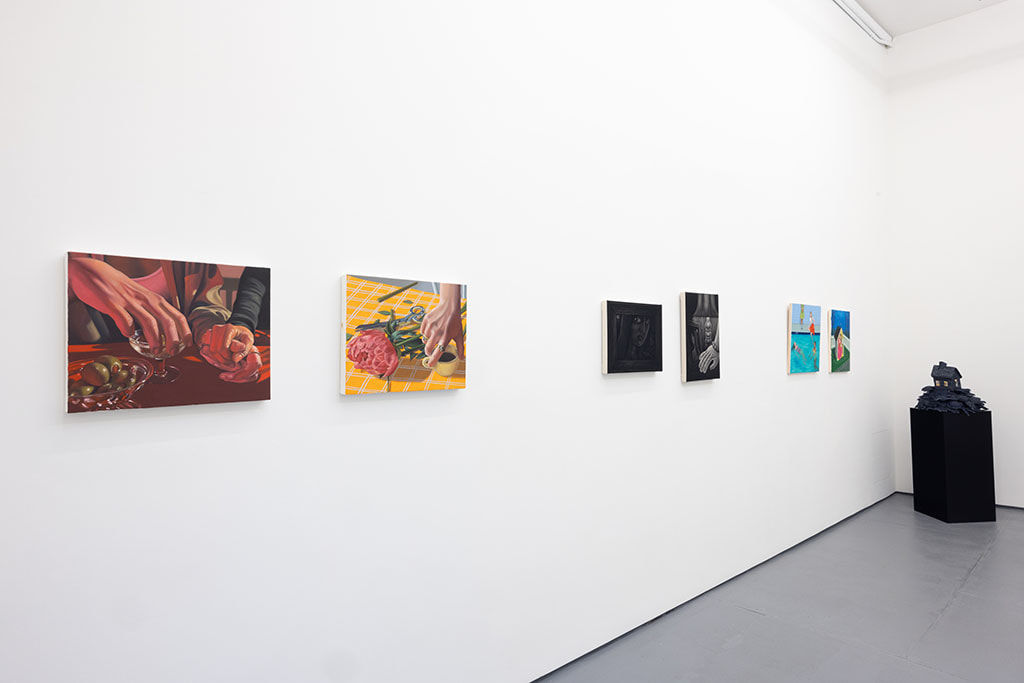 white gallery wall with paintings of various sizes