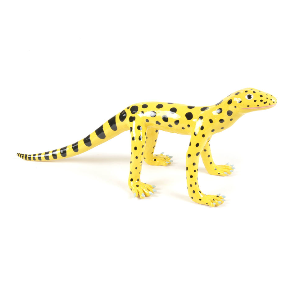 ceramic sculpture of a yellow lizard with a long tail and black polka dots