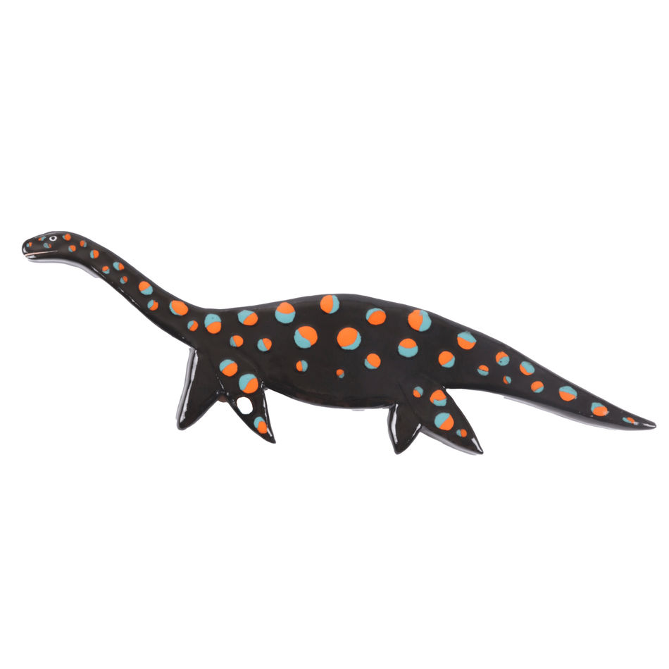 ceramic wall hanging of a black dinosaur with red and blue spots