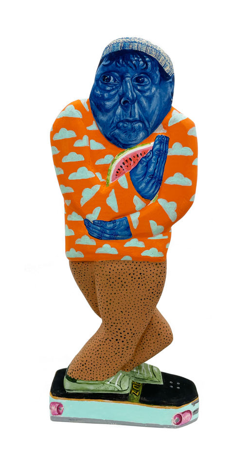 Sculpture of a man riding a skateboard holding a half of a watermelon. His face and beanie and blue and he is wearing an orange sweater with light blue clouds.