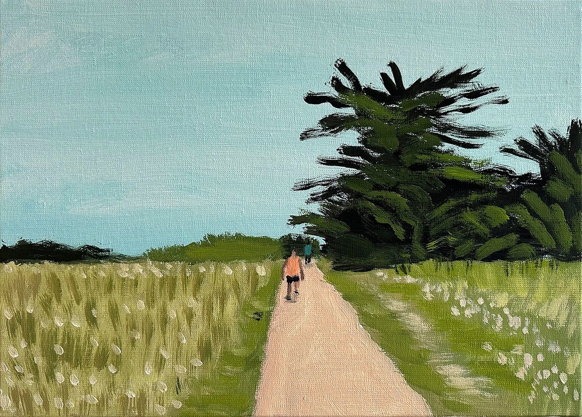 lone person walking a long a dirt path surrounded by grass