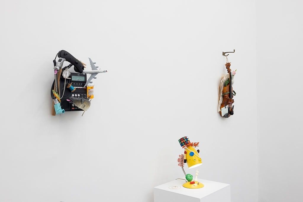 white wall with three different sculptures displayed