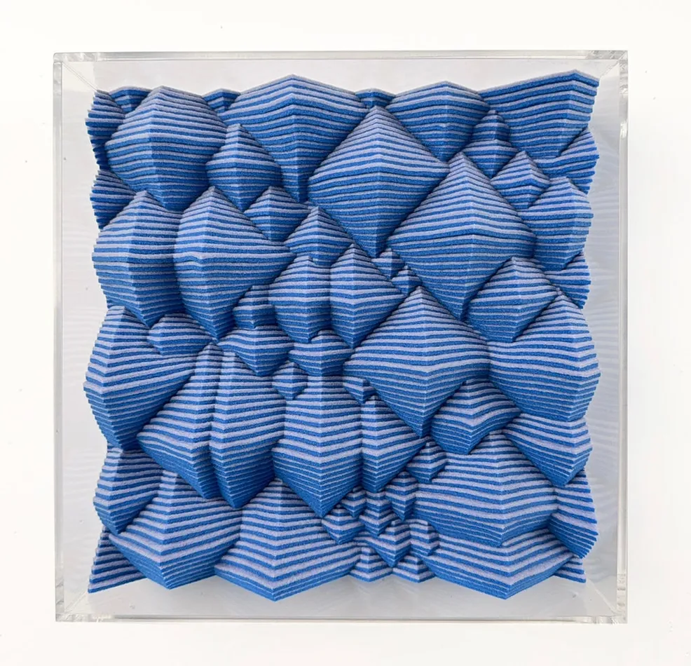 Blue textured square made from felt with a clear acrylic frame