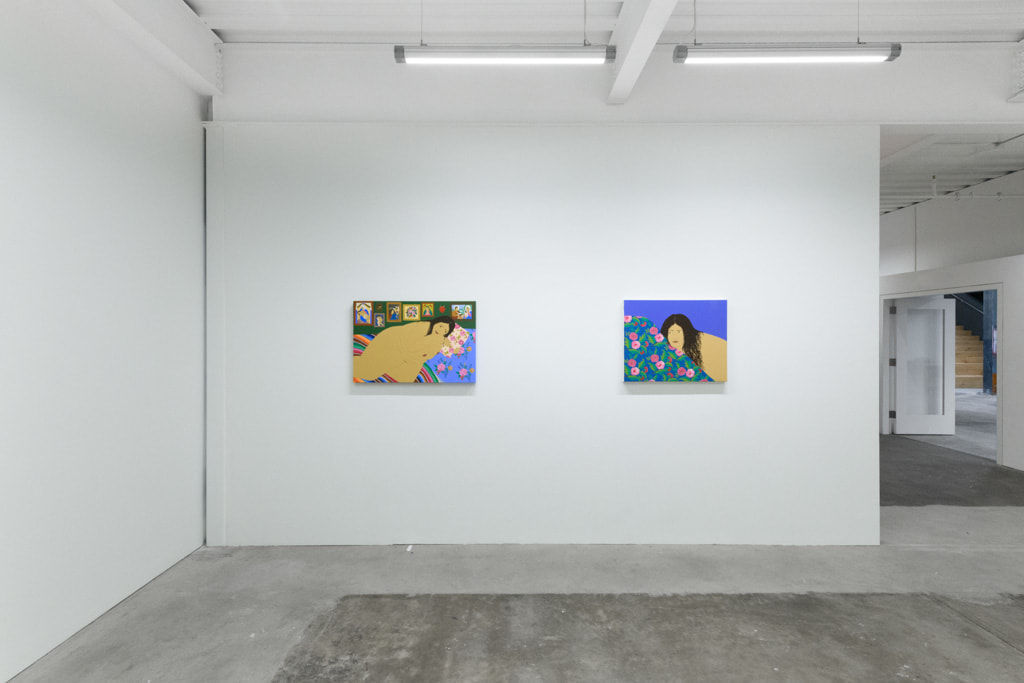 installation of Gina M. Contreras exhibition - two paintings of nude female figures with patterned blankets. From left to right 