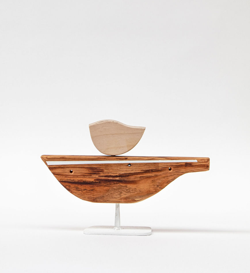 Wooden sculpture of a bird on a boat shaped object by Hyland Mather