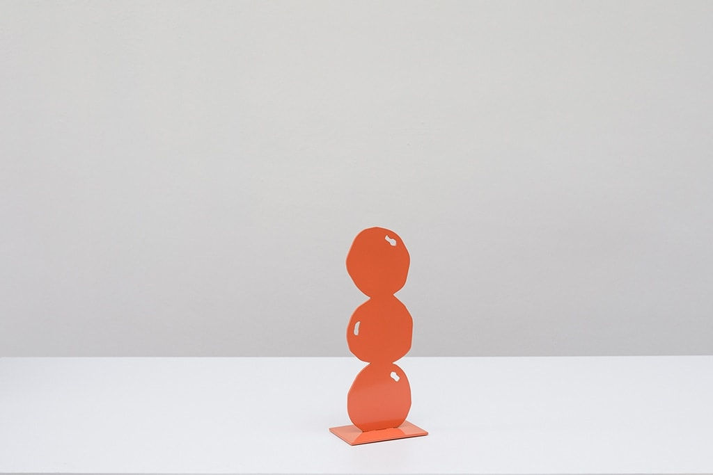 Metal sculpture of three peaches stacked on top of each other