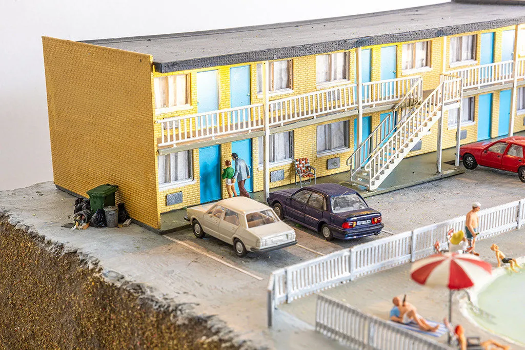 miniature diorama by Abigail Goldman of a woman bleeding on the ground in the parking lot of a motel