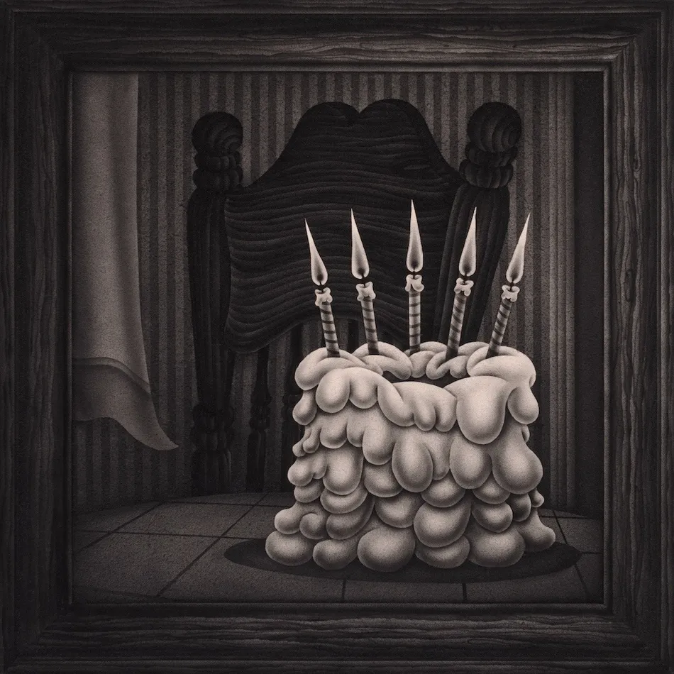 black and white painting on a cake with candles sitting on a table