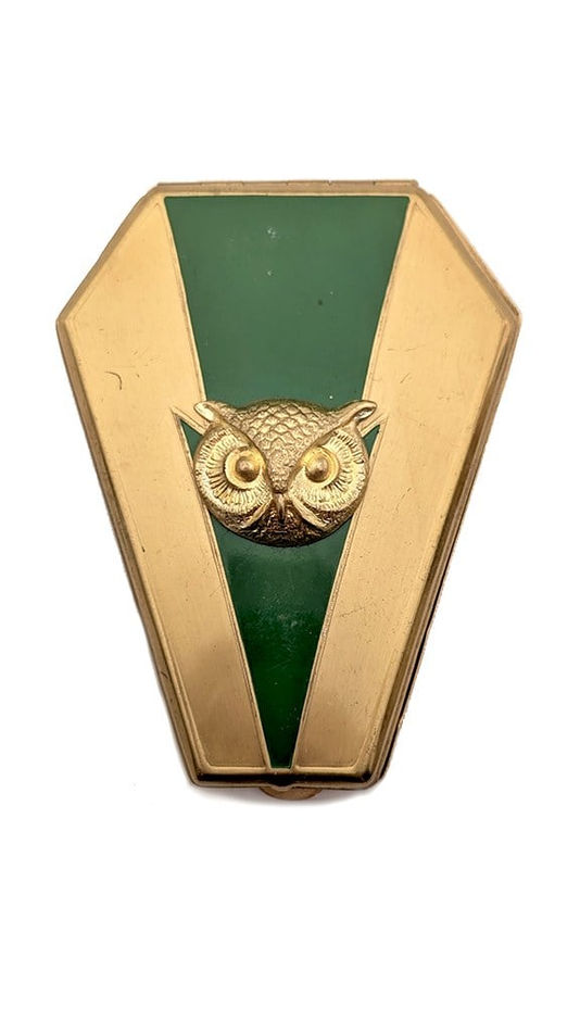gold compact with green triangle down the center and gold owl