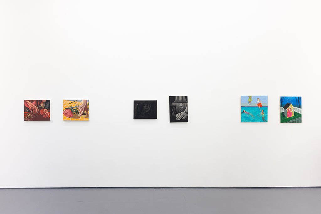 white gallery wall with paintings of various size and colors