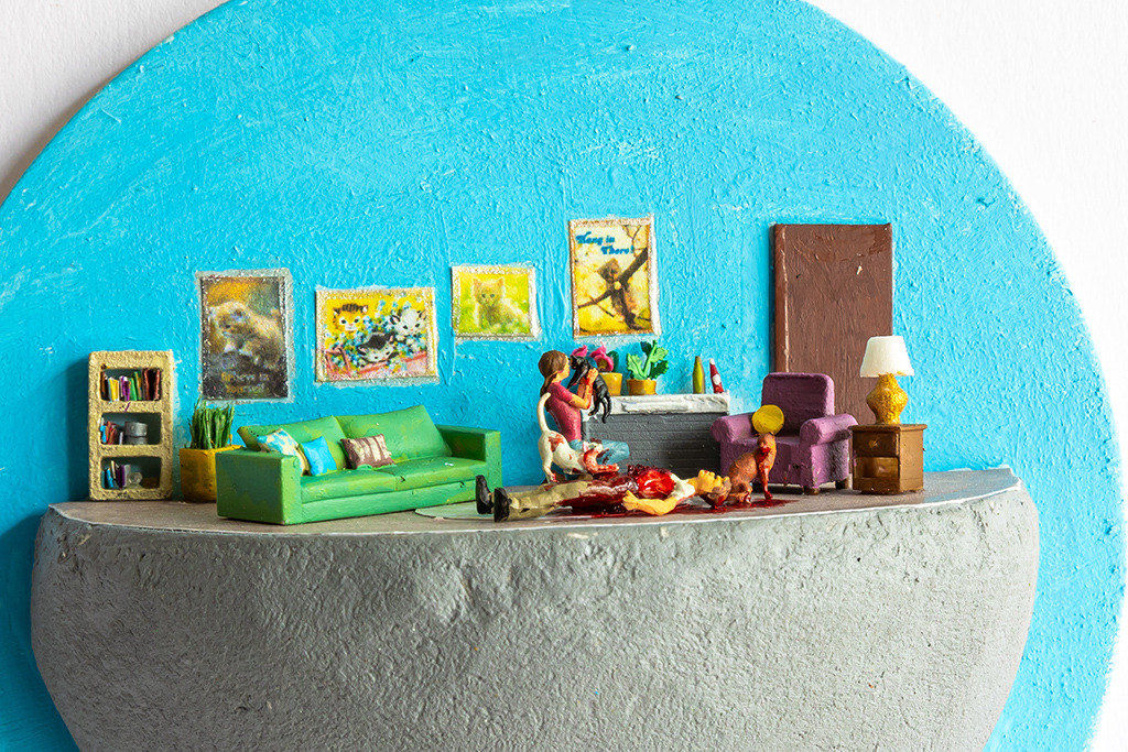 miniature diorama by Abigail Goldman of a woman and her three cats next to a bloody dead man