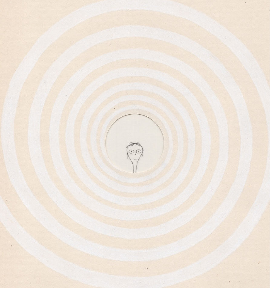 Paper cut out of a white spiral with a little wide eyed creature in the middle of it