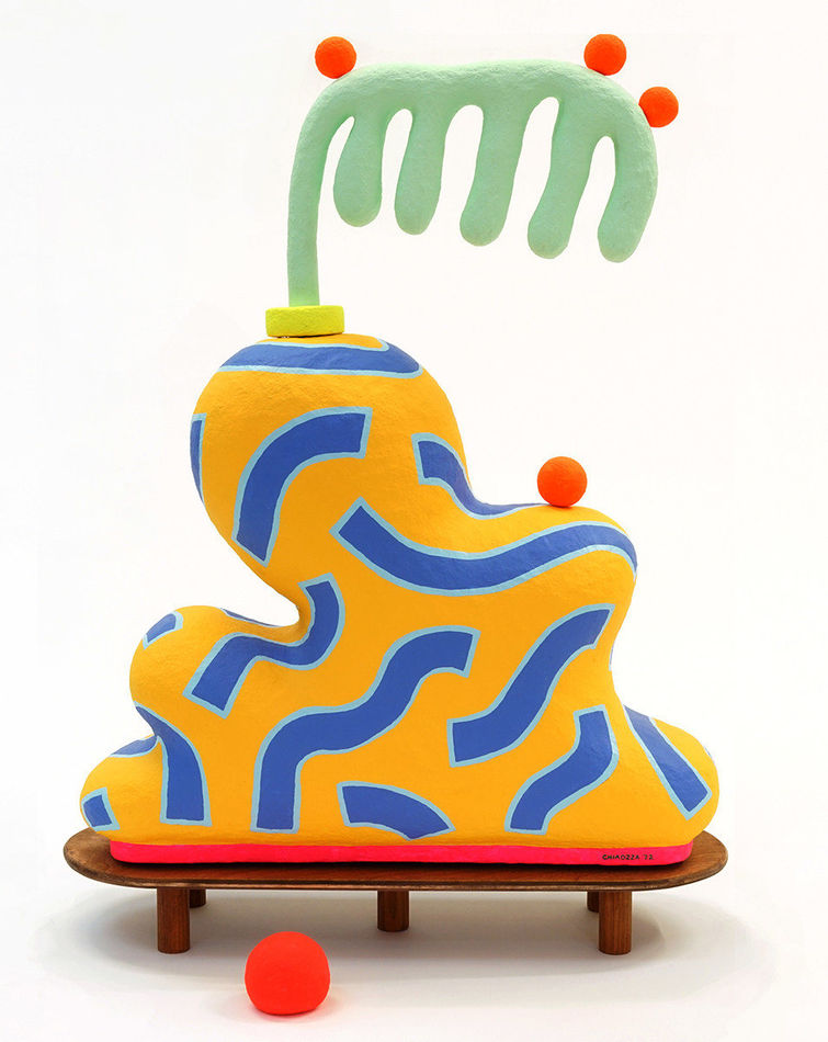 Chiaozza paper pulp sculpture of abstract yellow and blue vase with comb-like green plant on small wooden table base (alternate view)