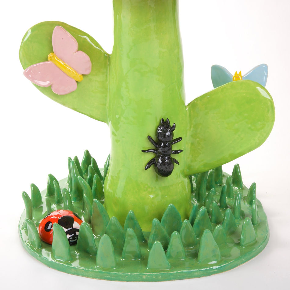 Lorien Stern's ceramic sculpture of an orange flower with grass and bugs