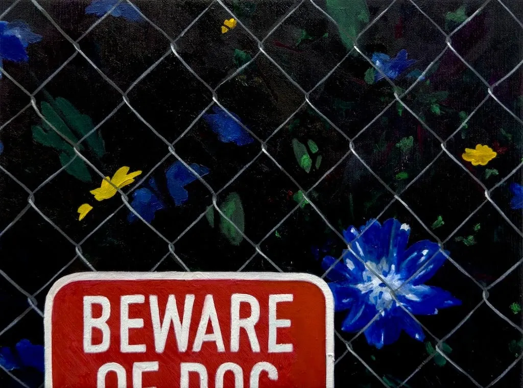 green leaves, blue and yellow flowers behind a wire fence and a red 