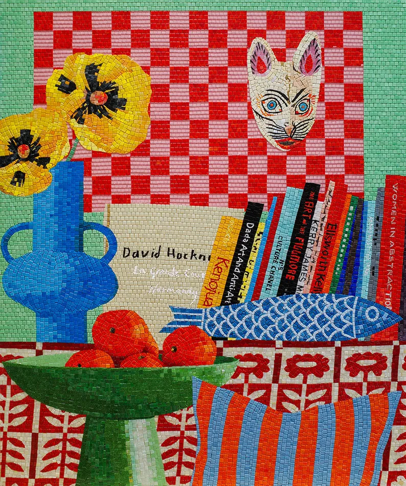 Mosaic still life of an interior with several stacked books, a blue vase with yellow flowers, a green bowls filled with oranges and a cat mask hanging on a pink and red checkered wall.