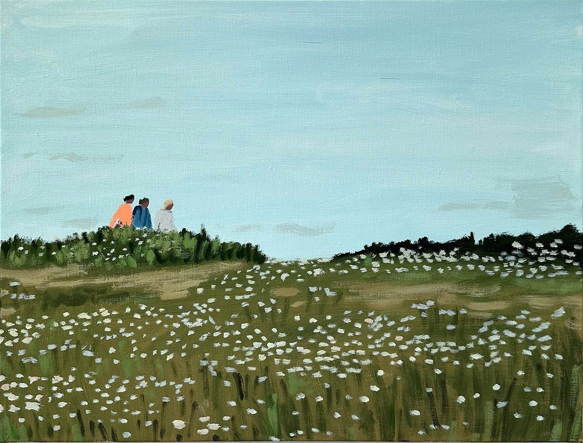 three figures in the distance walking through a field
