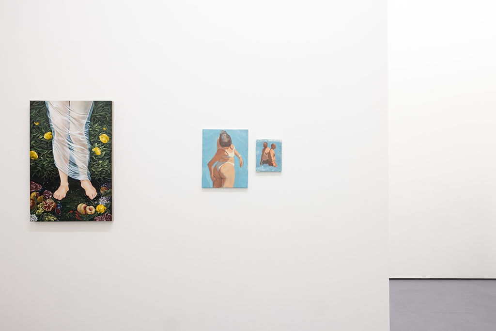 white gallery wall with paintings of various sizes