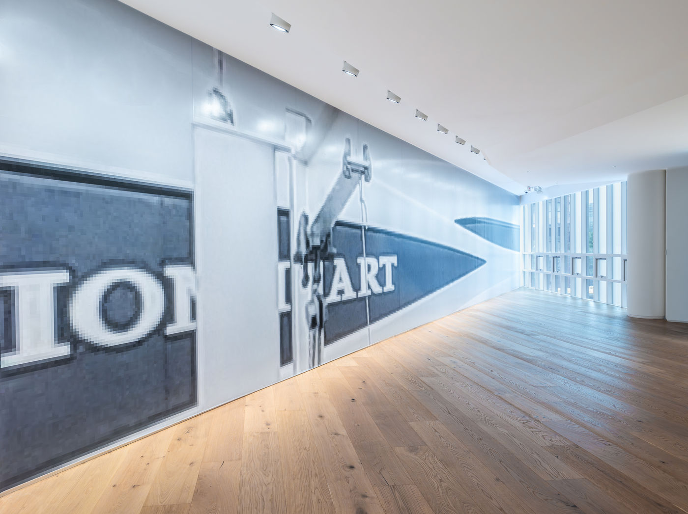 메가 요트 &lsquo;라이언하트(Lionheart)&rsquo;의 이미지가 전시장 벽을 가로질러 부착되어 있다. 이는 세계에서 가장 큰 메가 요트들의 이미지를 활용하는 작가의 연작 ⟨플라잉...