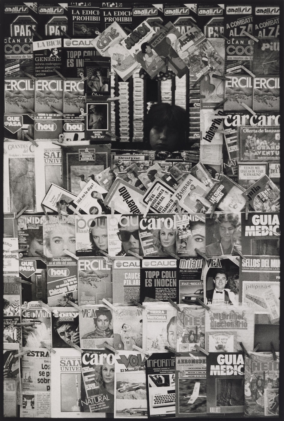 거리의 신문 가판대를 포착한 이 사진은 리드미컬한 이미지를 표지로 내세운 잡지들이 수직으로 나란히 배열된 구성을 담고 있다. 마이클 잭슨과 화장품...
