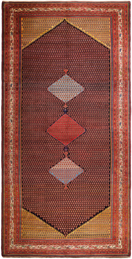 this rectangular antique saraband rug contains three diamonds going down vertically encased in a long hexagonal shape. the diamond's colors are light blue, red, and light blue. there are several small motifs lining the entire rug which creates a bit of a dotted effect on the rug.